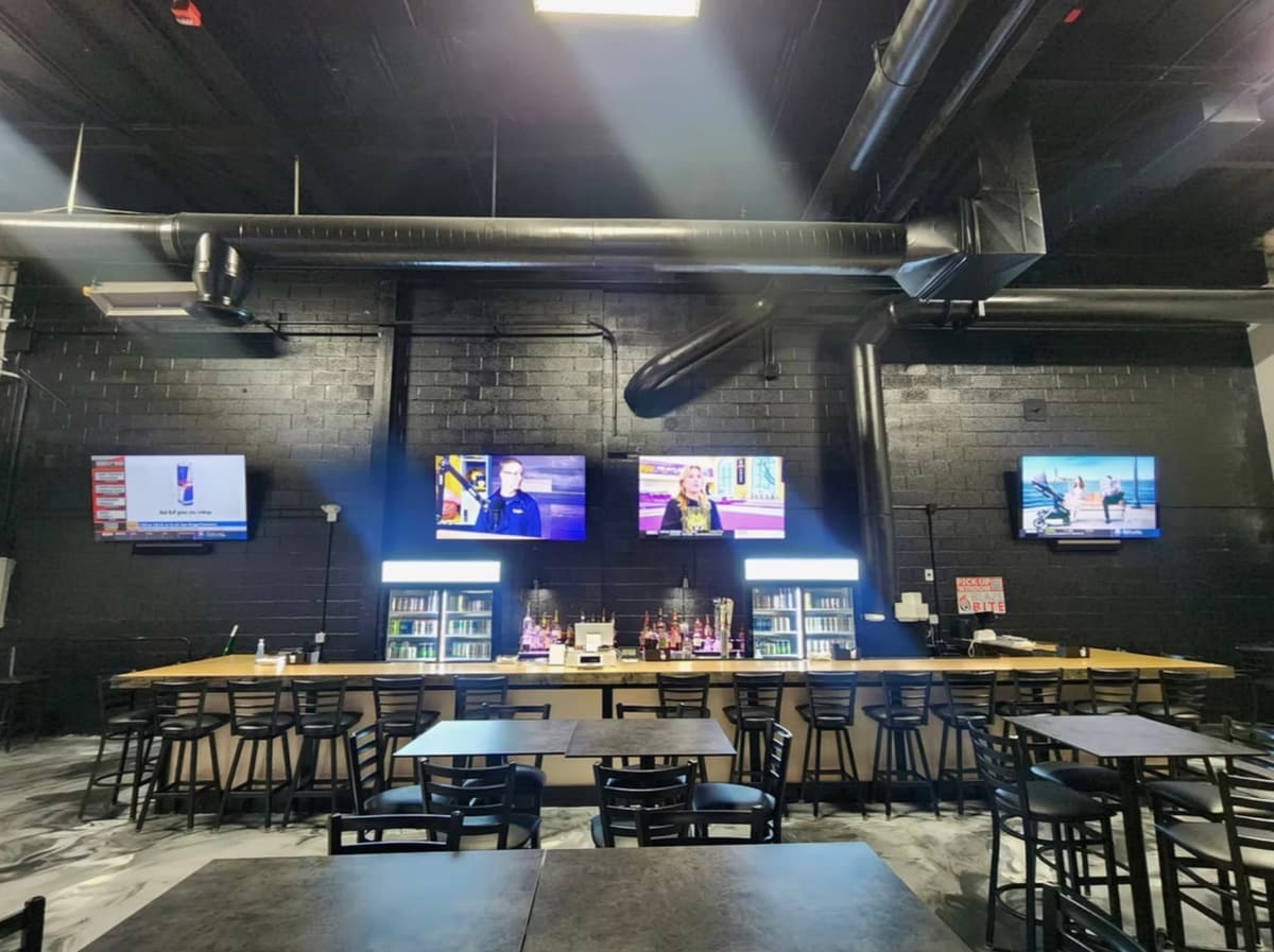 The bar and TVs at XXI Hoops inside NEO Sportsplant
