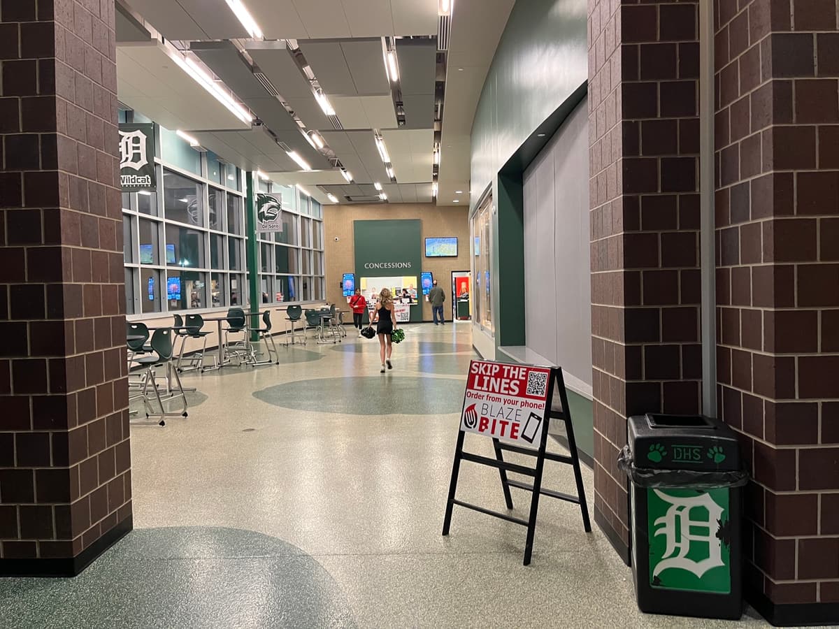 A Skip the Lines BlazeBite sign on an easel in an arena lobby