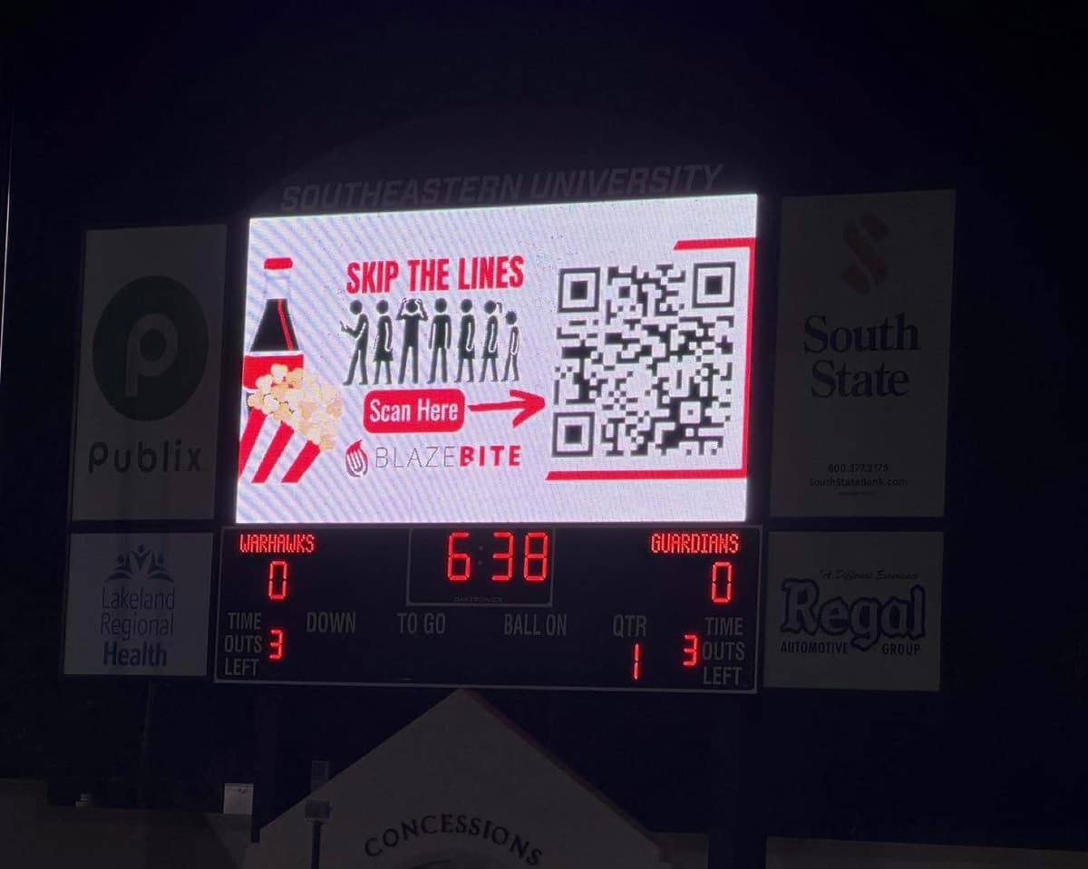 A Skip the Lines BlazeBite ad on a stadium scoreboard