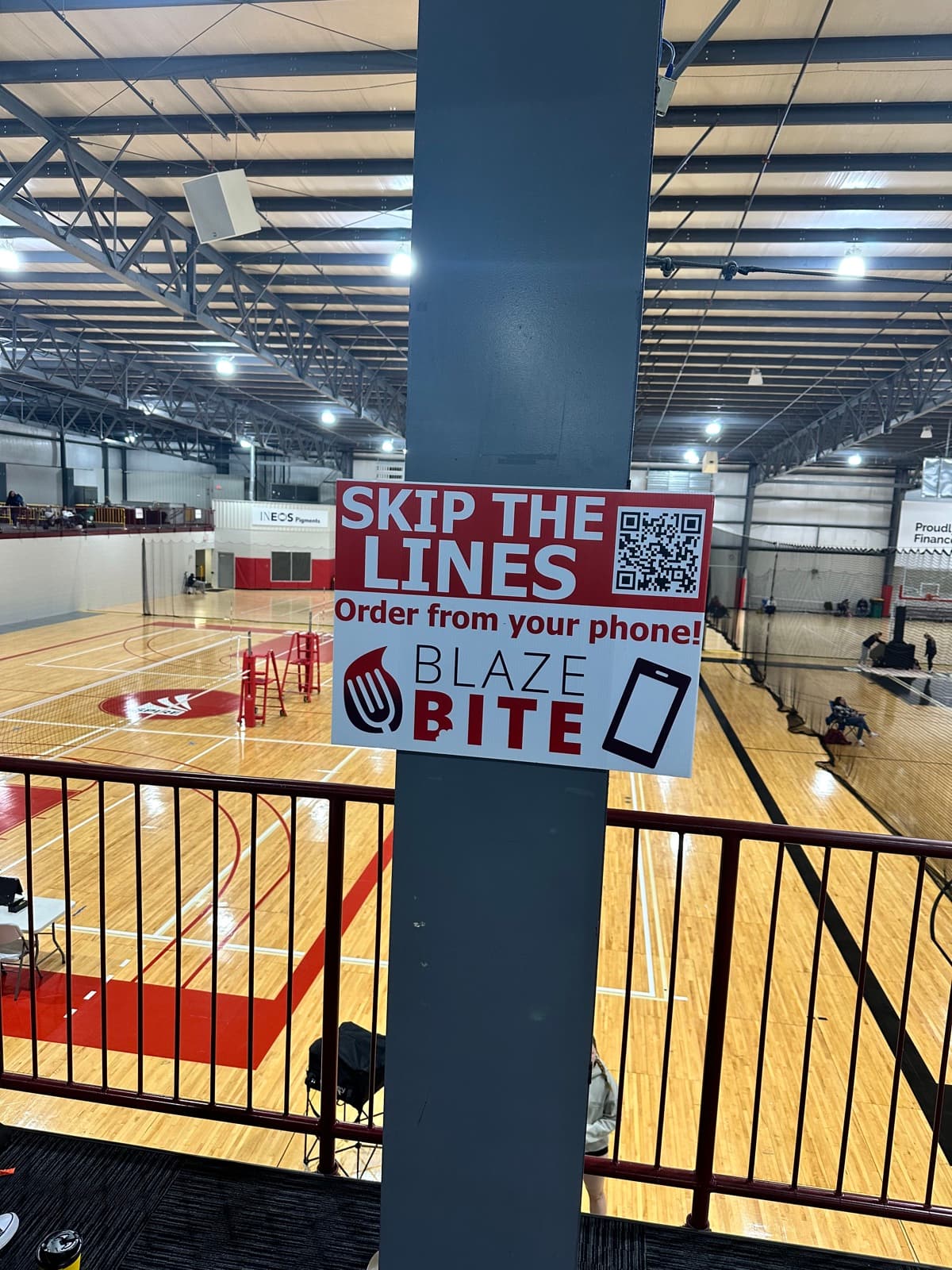 A Skip the Lines BlazeBite sign on a pillar overlooking the courts at Spire