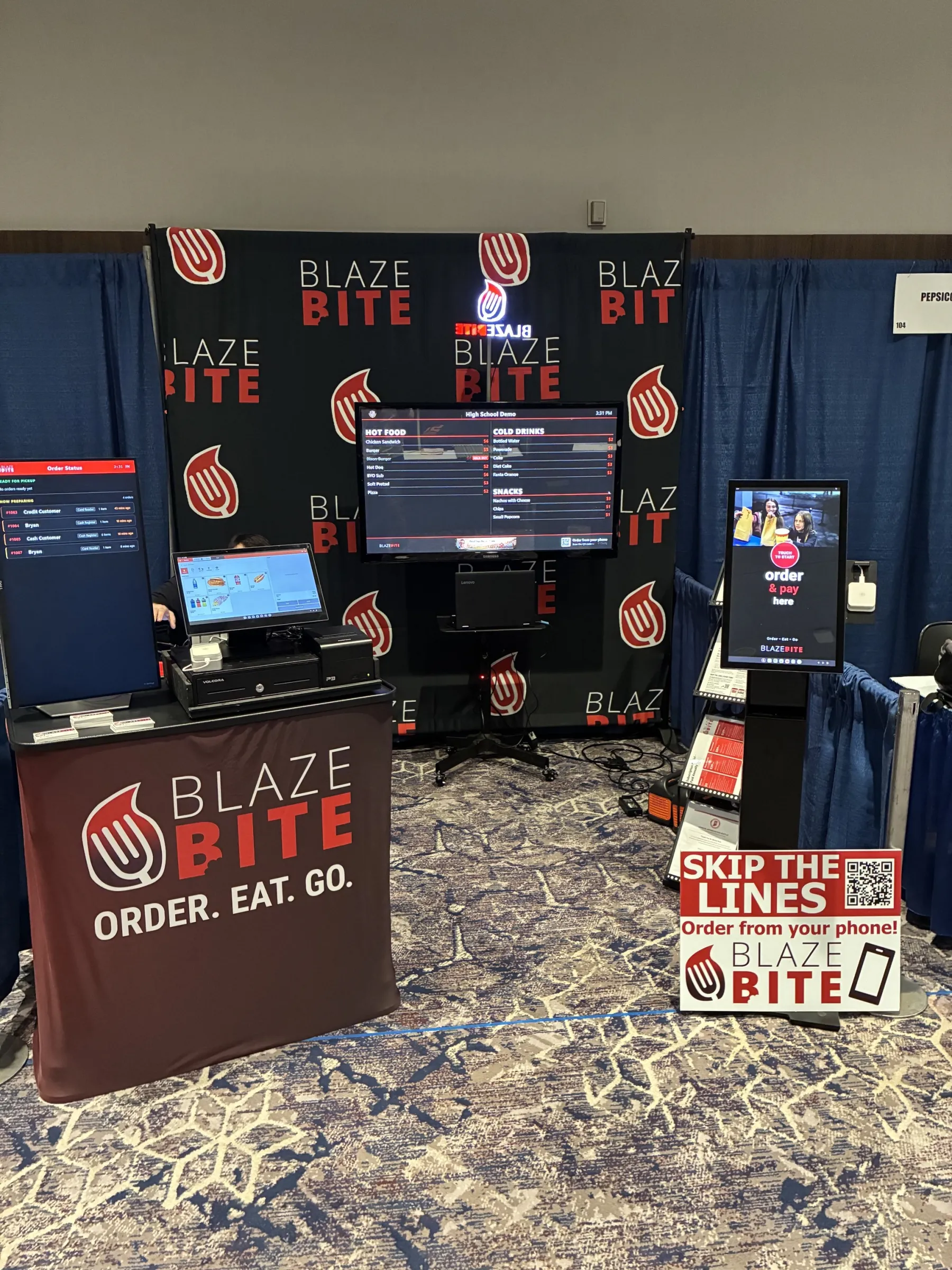 BlazeBite concession setup with menu board, POS, and self-order kiosk