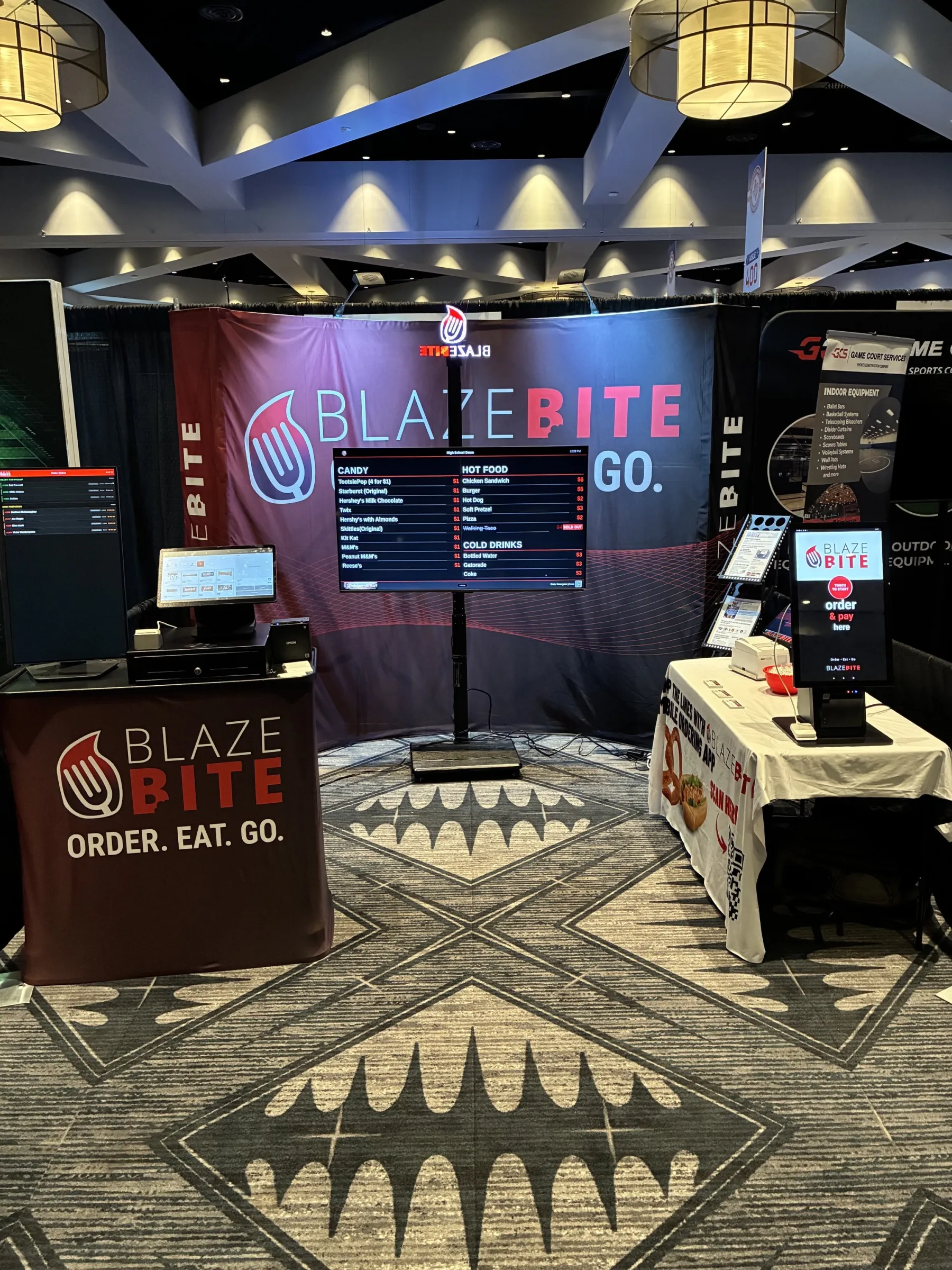 BlazeBite digital menu board at an event with branded backdrop