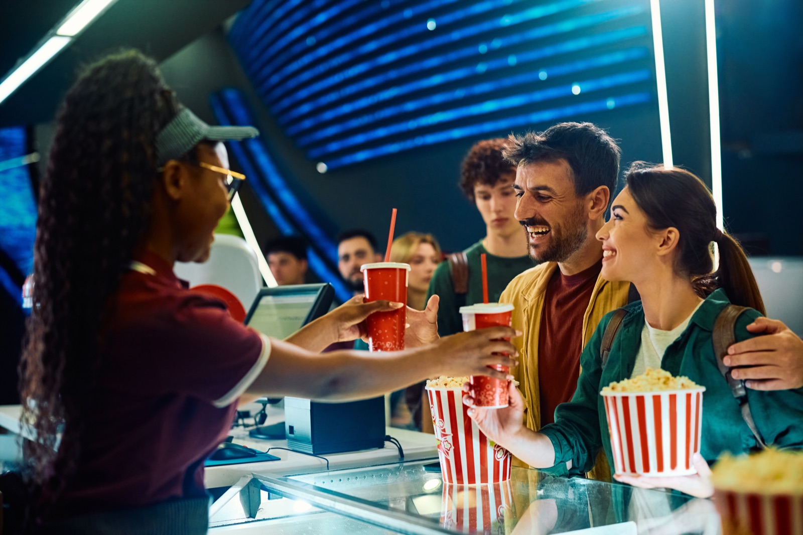 Happy couple buying concessions at a modern movie theater
