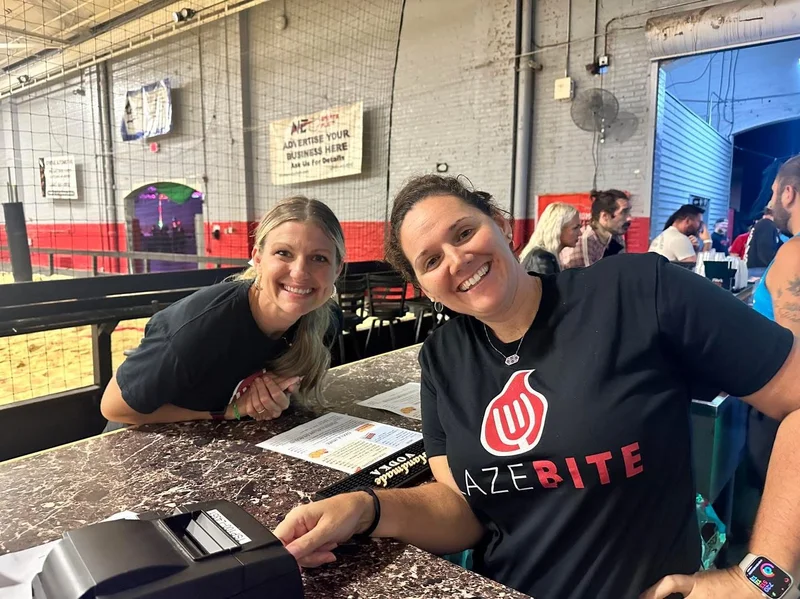 Two BlazeBite staff at a concession counter with a card reader